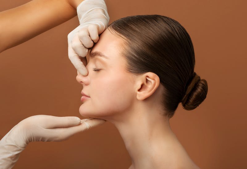 doctor hands touching womans nose