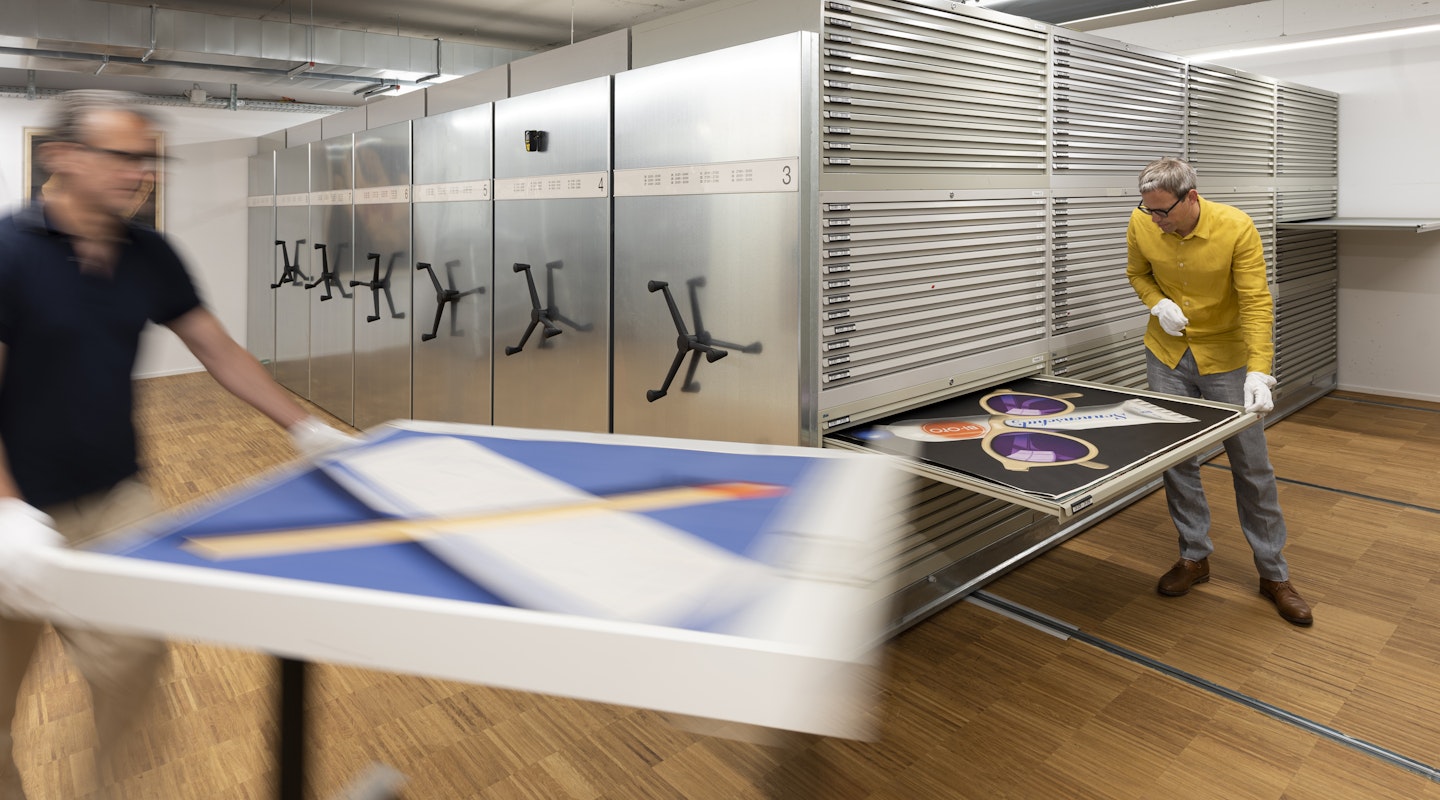 Mitarbeiter heben Plakate aus dem Archiv aus