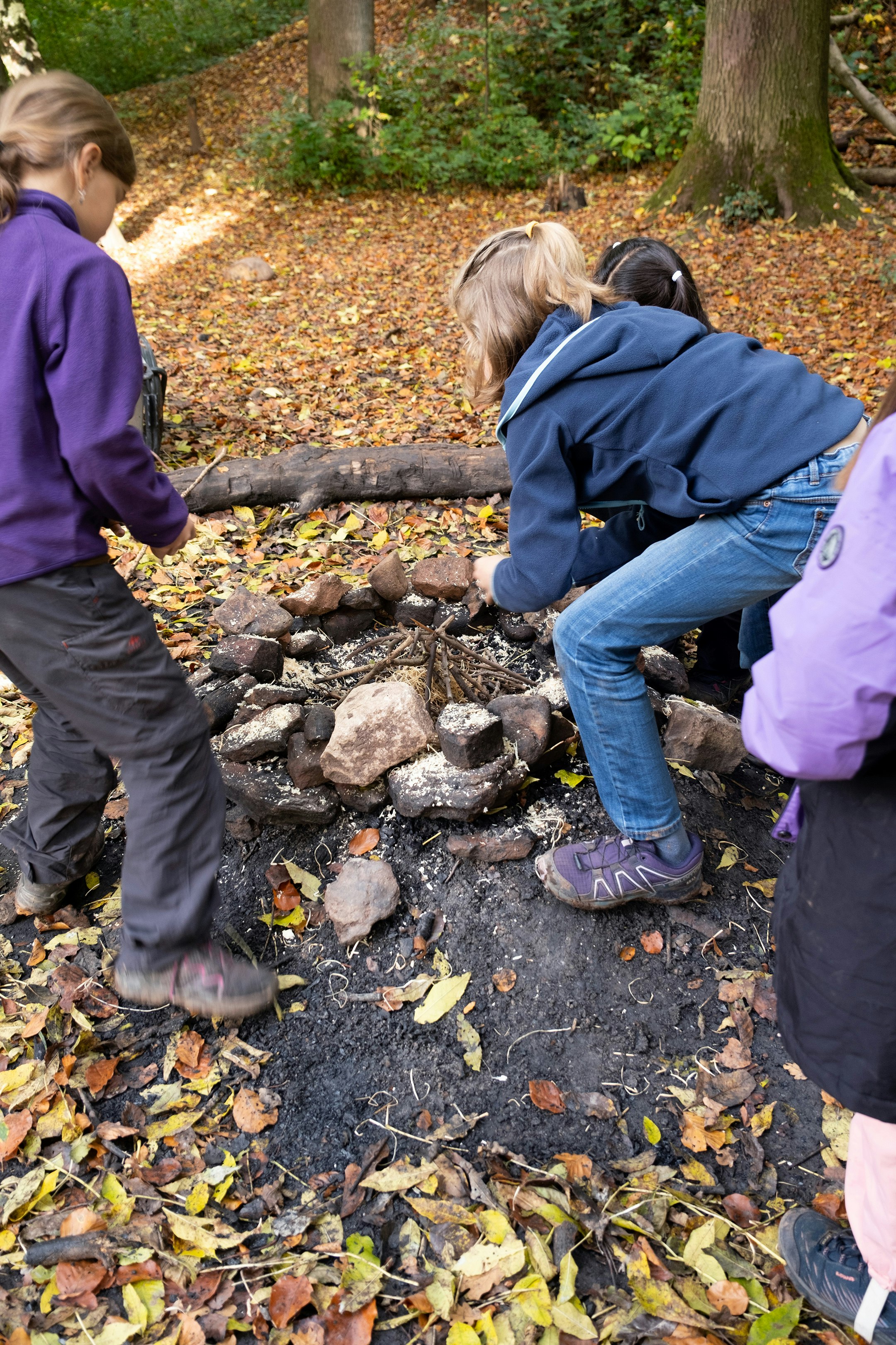 Kinder entfachen im Wald ein Feuer.