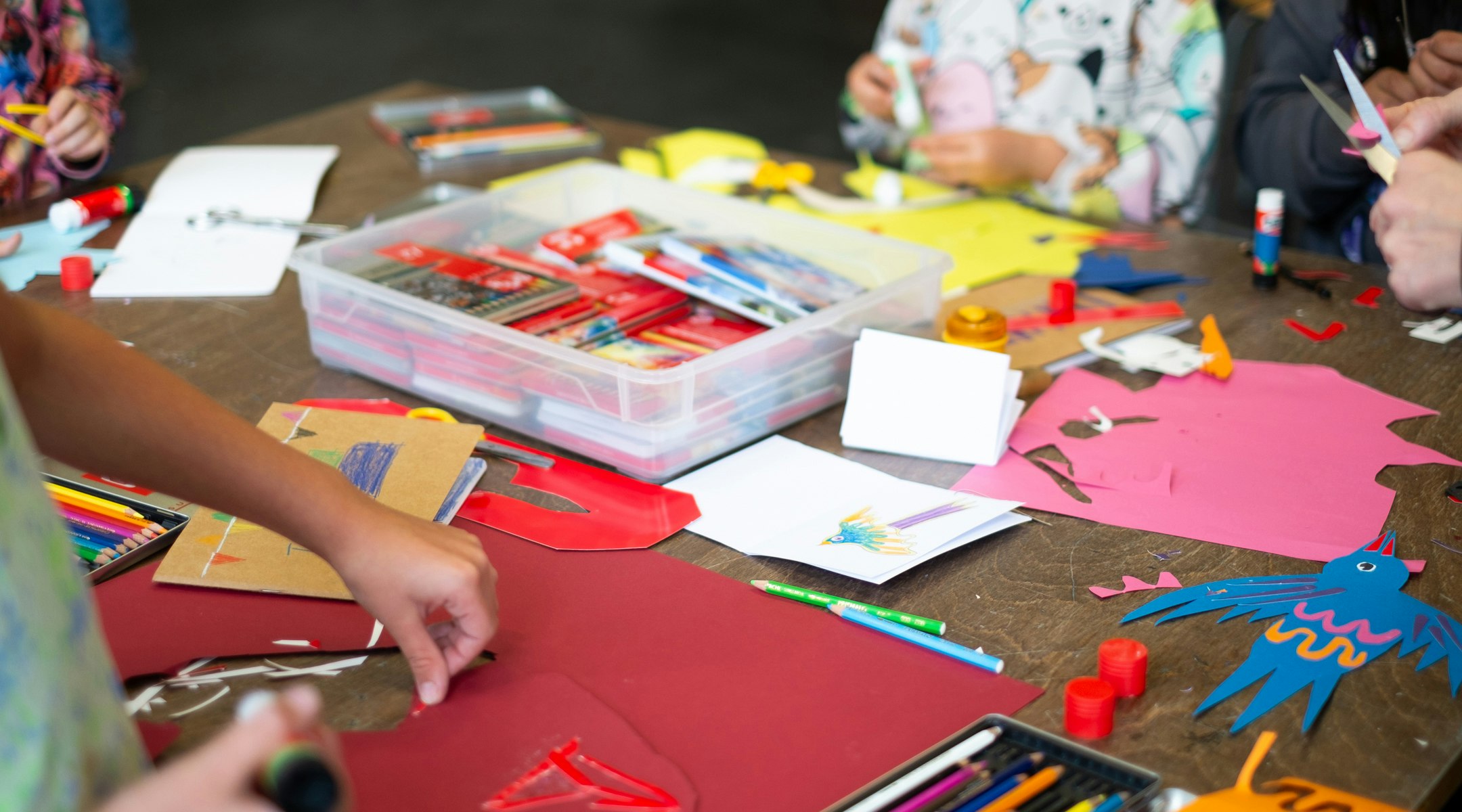 Arbeitstisch mit Papier Stiften, Scheren, Kinder am gestalten