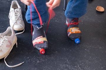 Füsse mit lustigen Schuhwerken aus Stoff und Klebeband und Petflaschen, Modelabor