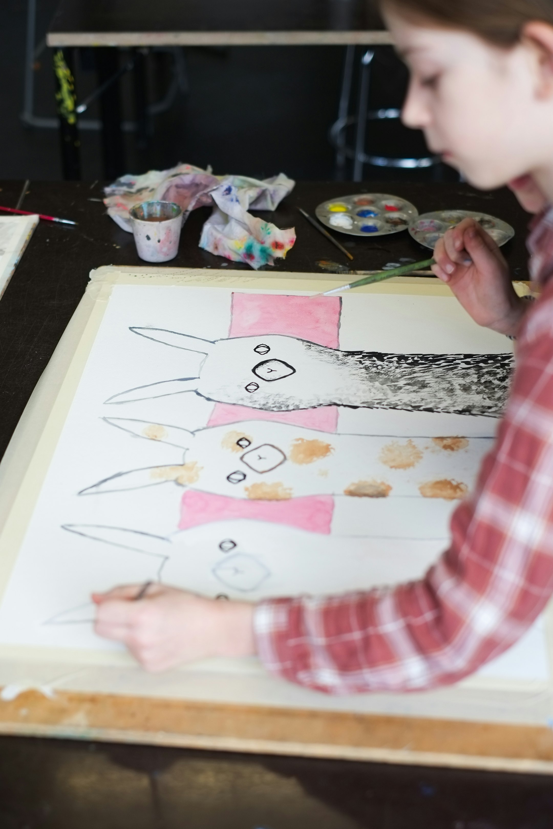 Kind malt ein Bild mit drei Lamas