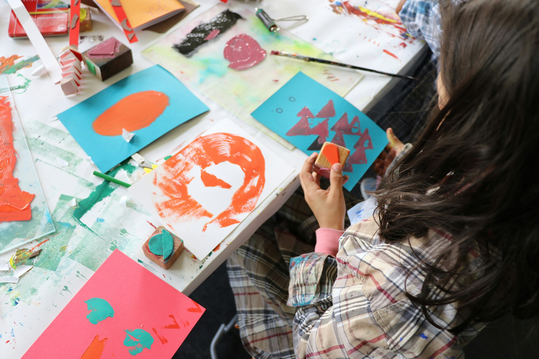 Kind am Drucken und Stempeln, Farbiges Papier, Arbeitstisch