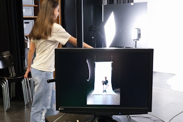 Aufnahme im Fotostudio, Bildschirm, Mädchen im Hintergrund