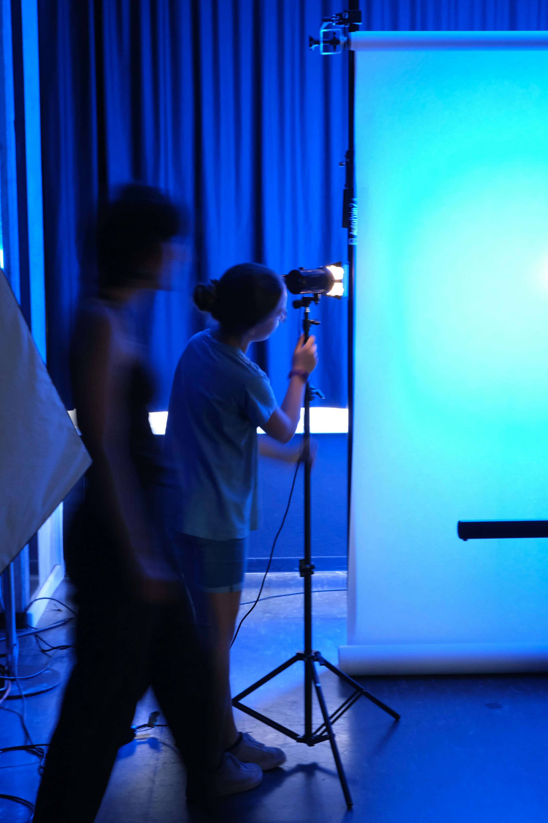 Aufnahme im Fotostudio, zwei Personen, Kamera, blaues Licht