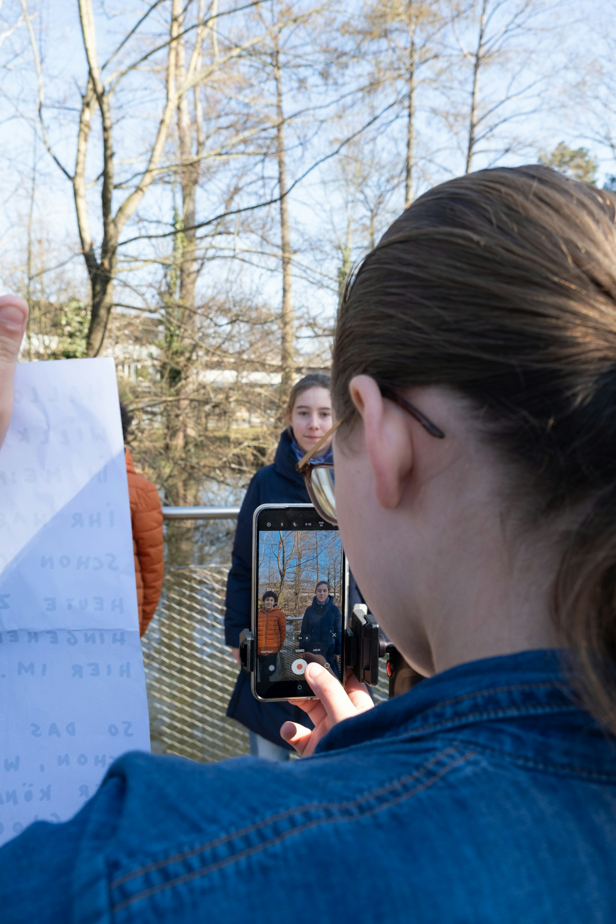 Aufnahmesetting mit Handy, Text, Person im Hintergrund