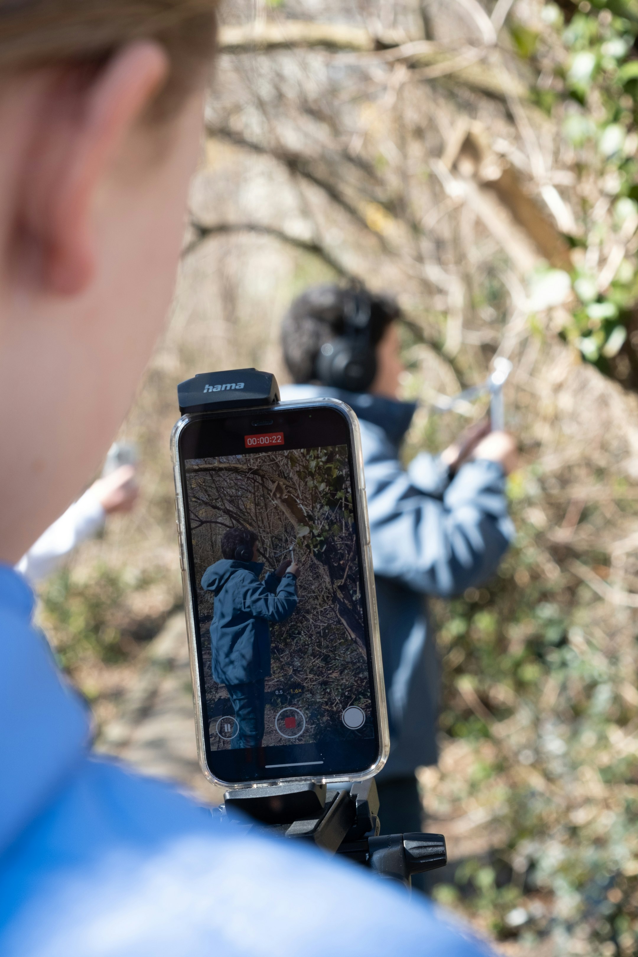 Aufnahmesetting mit Handy, Text, Person im Hintergrund