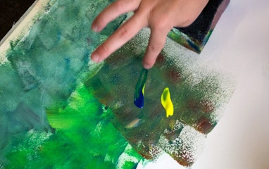 Mit den Fingern auf einem Blatt Papier malen.