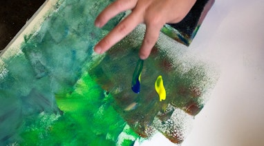 Mit den Fingern auf einem Blatt Papier malen.