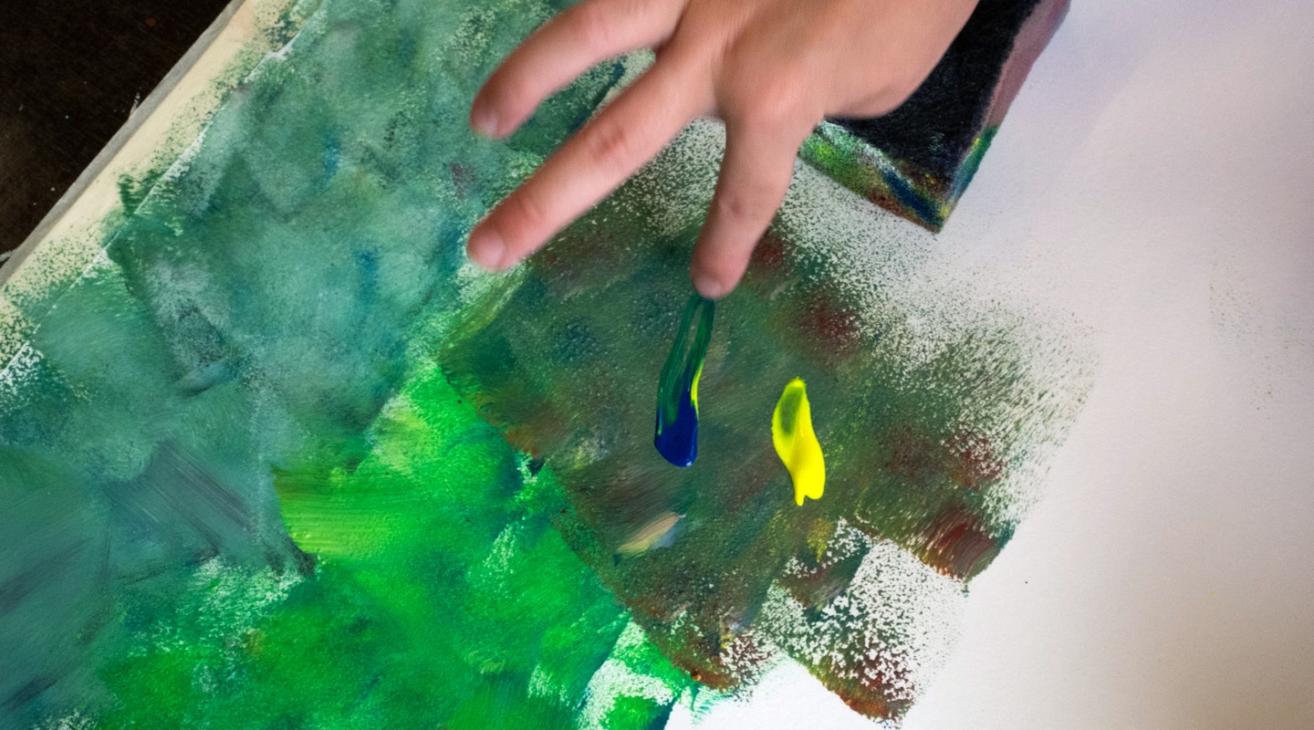 Mit den Fingern auf einem Blatt Papier malen.