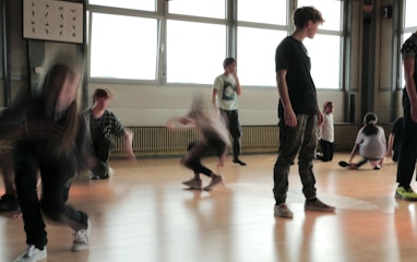 Kinder und Jugendliche tanzen in einem Raum.