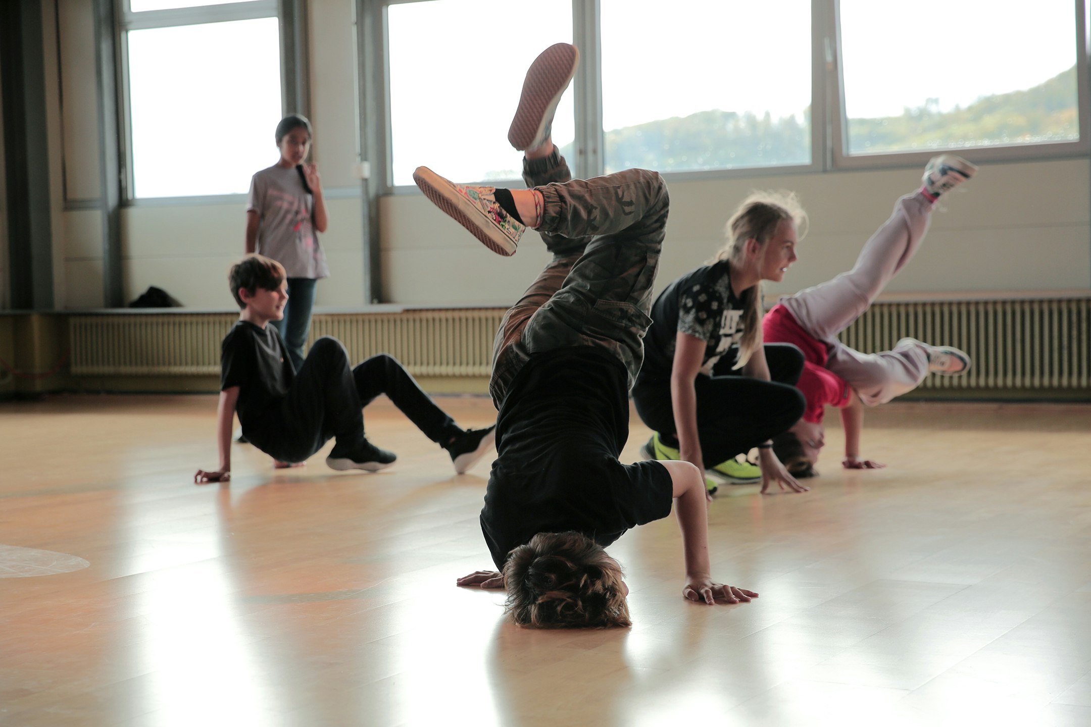 Kinder und Jugendliche tanzen in einem Raum.