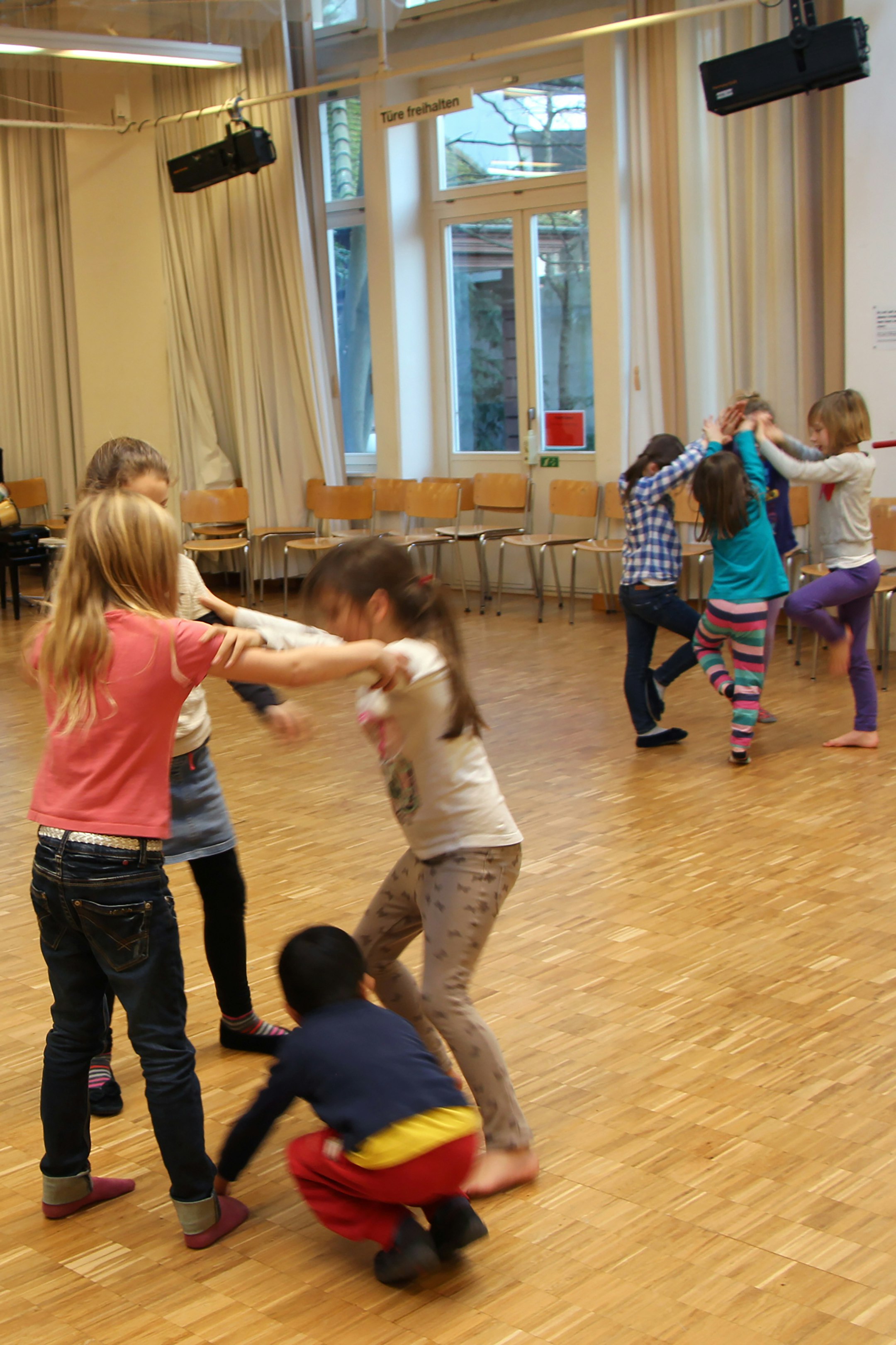 Kinder tanzen in einem Raum.