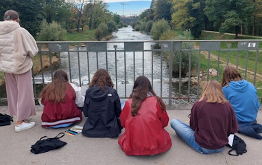 Jugendliche skizzieren draussen sitzend