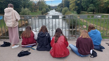 Jugendliche skizzieren draussen sitzend