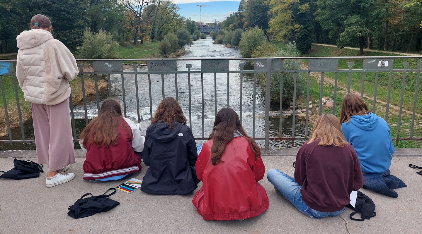 Jugendliche skizzieren draussen sitzend