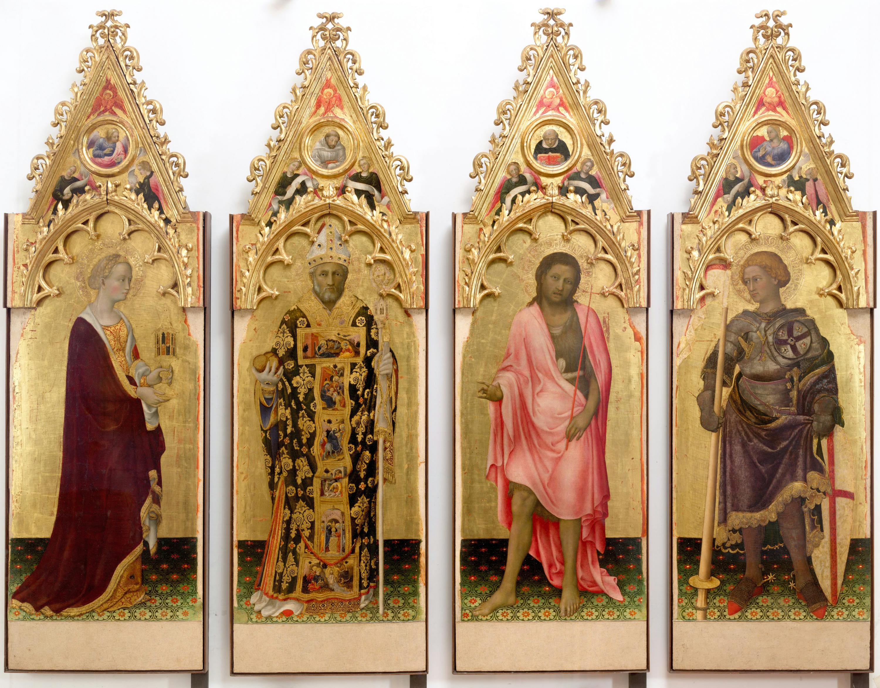 I santi Maria Maddalena, Niccolò, Giovanni Battista, Giorgio  Nelle cuspidi: l’angelo annunciante, i santi Bernardo di Chiaravalle e Domenico; la Vergine annunciata