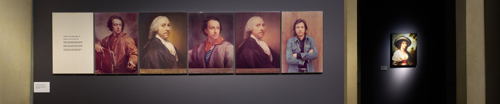 A gallery exhibit showcasing five historical portrait paintings on a dark gray wall, each depicting different individuals with varied attire and expressions, alongside a smaller illuminated portrait in an adjacent dimly lit room; the scene conveys a strong sense of tradition and artistic heritage.