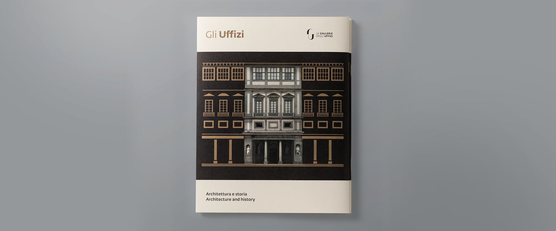 L'immagine mostra una copertina di un libro intitolato "Gli Uffizi", con un'illustrazione dettagliata della facciata architettonica del celebre museo fiorentino su uno sfondo grigio chiaro.