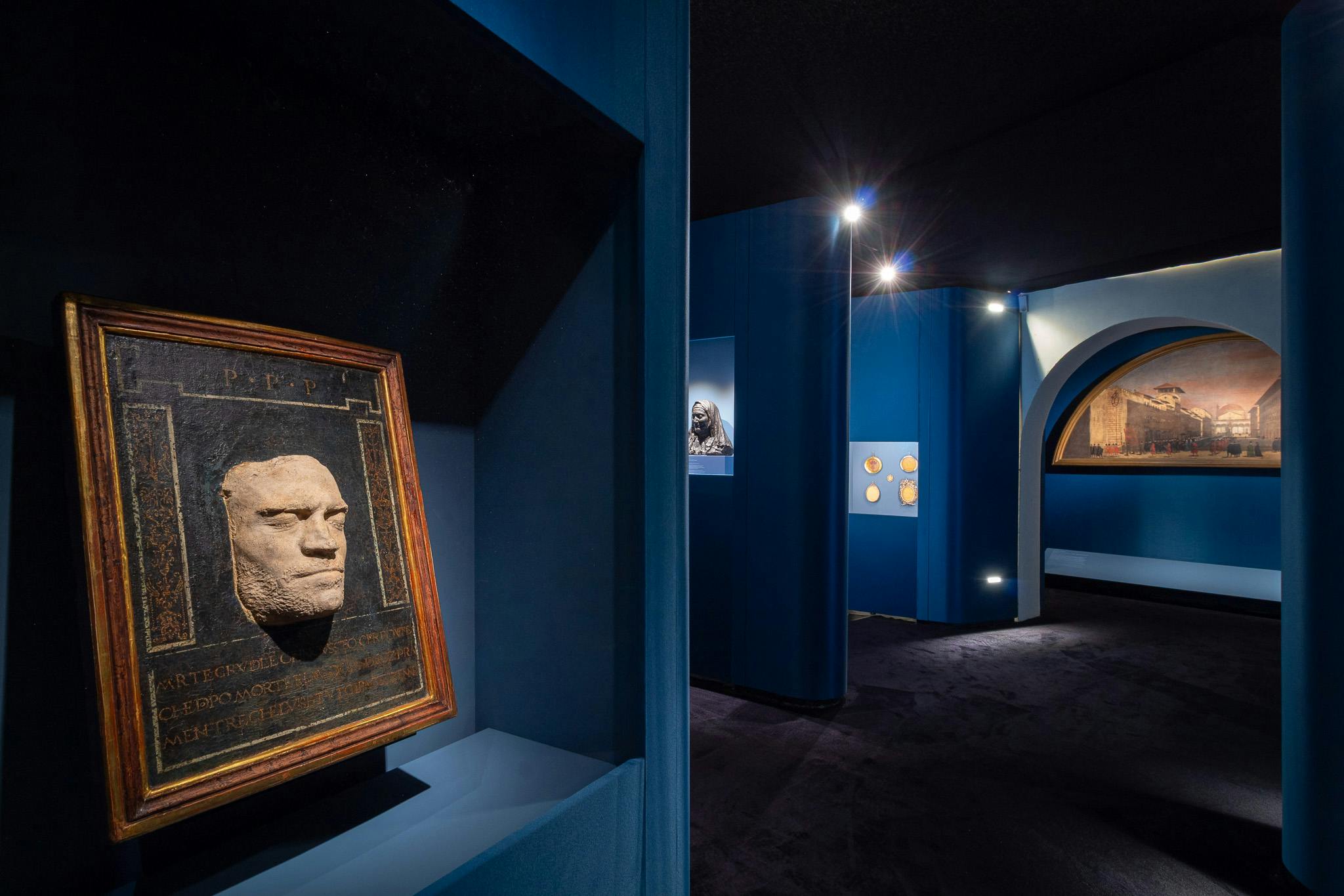 Orsino Benintendi, attributed (Florence, 1440 - after 7 October 1504) and Giovanni Antonio Sogliani, attributed (Florence, 1492-1544), Funeral mask of Lorenzo de' Medici, the Magnificent 1492 and 1512-1513 or 1515, patinated plaster, painted and gilded frame, at the top “p.p.p.”, at the bottom 'cruel death that / came upon this body / that after death the world went on / while he kept everything in peace ', Florence, Academy of Sciences and Letters La Colombaria, on deposit at the Uffizi Galleries, Palazzo Pitti, Treasury of the Grand Dukes Exhibition ‘Wax upon a time’, photos of the exhibition setup