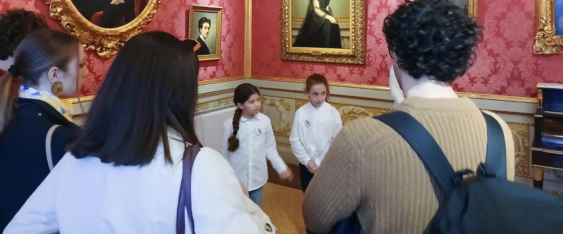 Gli Ambasciatori dell'Arte Juniores guidano alcuni visitatori alla scoperta di Palazzo Pitti nell'ambito delle attività educative organizzate nel museo.