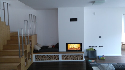 Kamin z ravnim steklom, počivalno klopjo in režo za drva