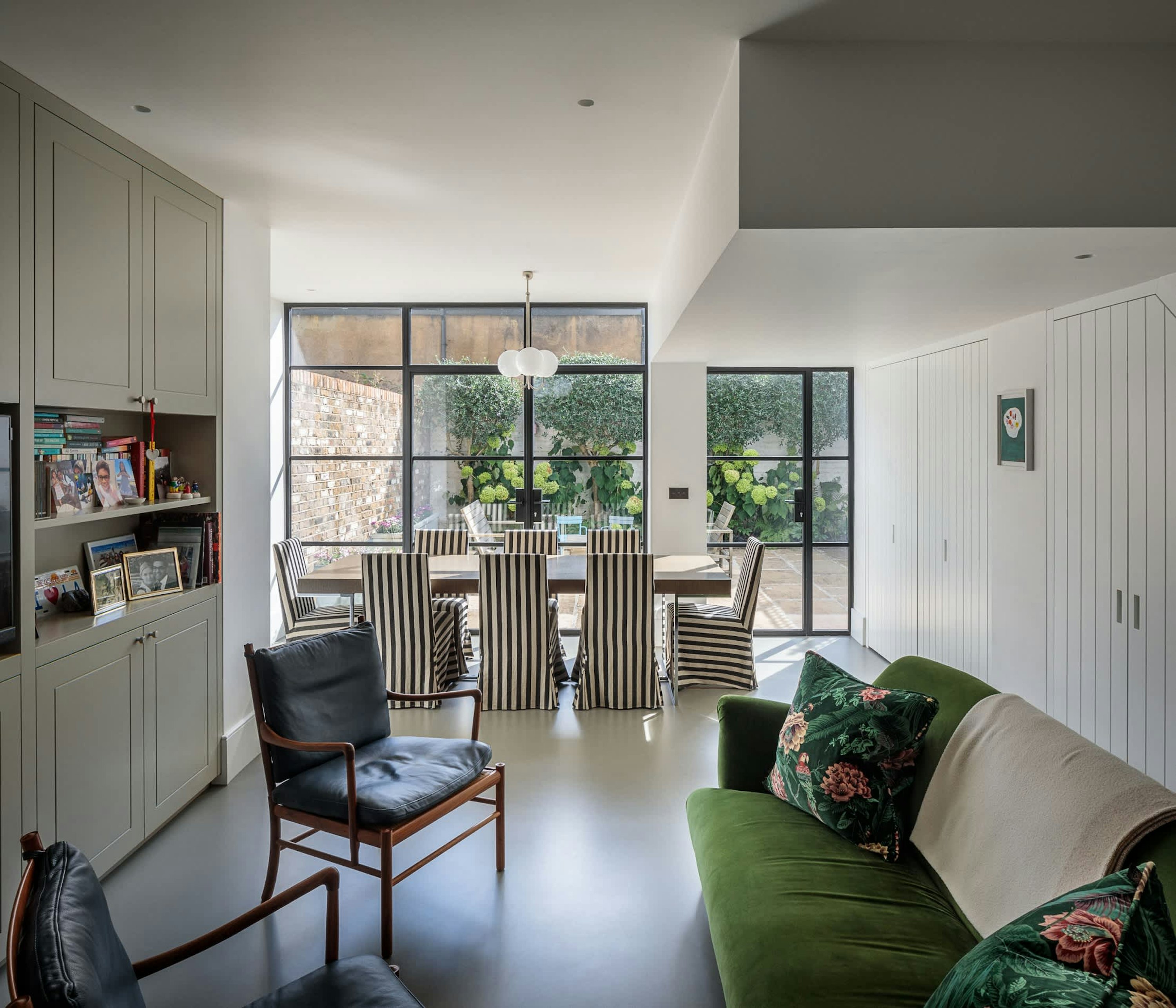A Victorian terrace house extension with a dining room and living space, and garden views via floor-to-ceiling critall windows.