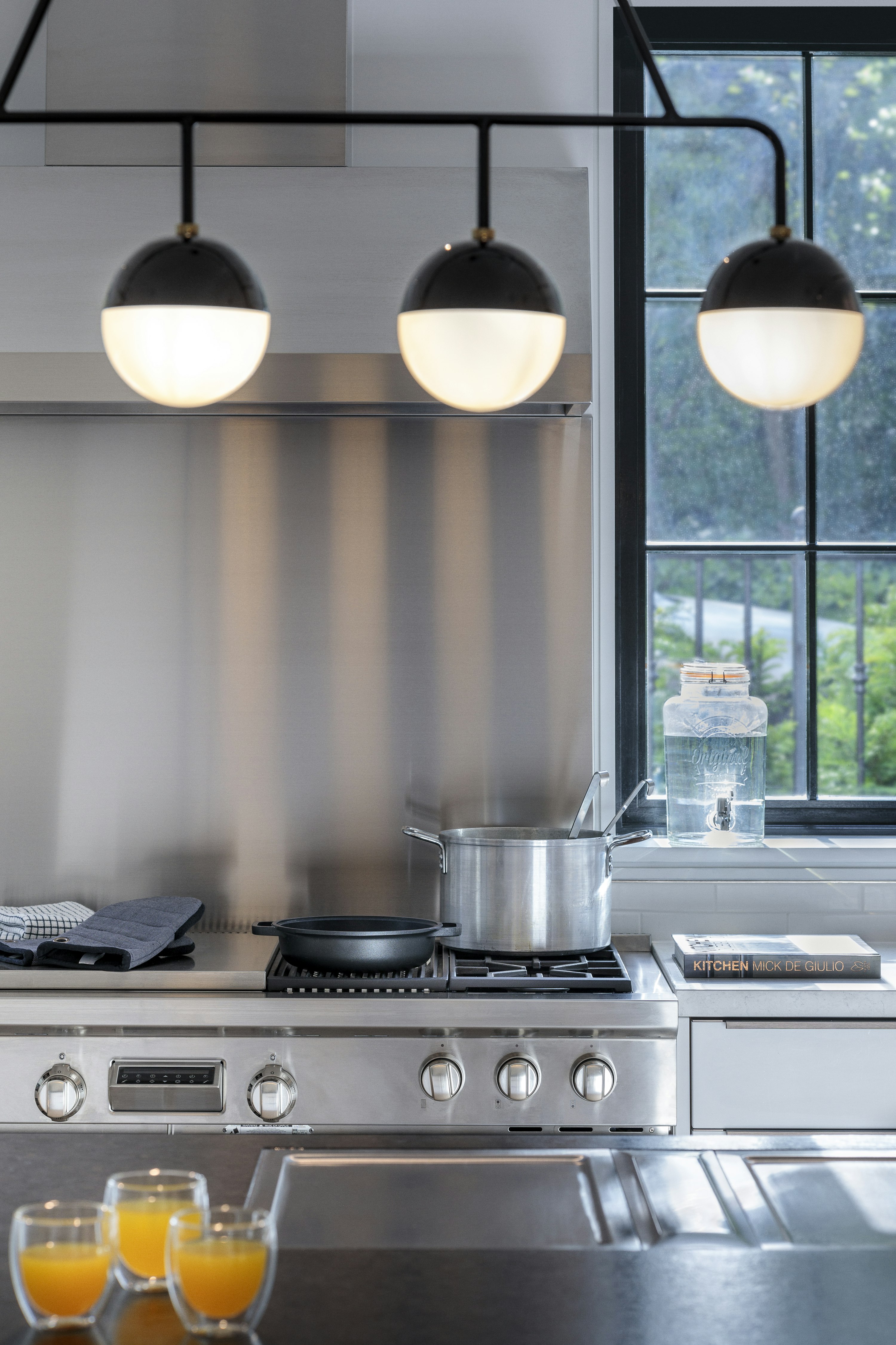 High-end stainless-steel appliances, including a Wolf Range Oven, in a contemporary kitchen, with a pendant light above.