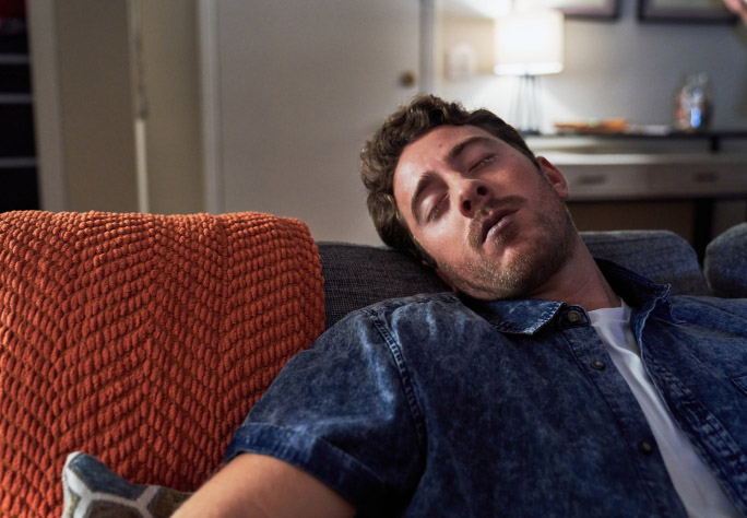 Man with blue lips passed out on couch.