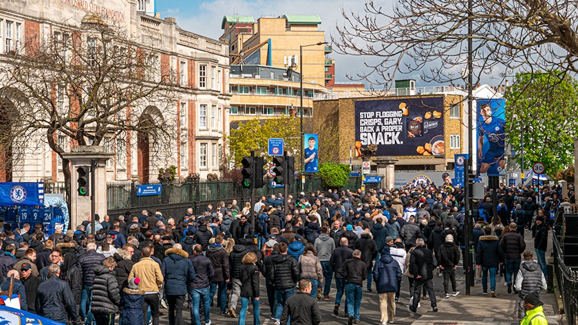 Football fans walking into a stadium with Jungle client on a billboard