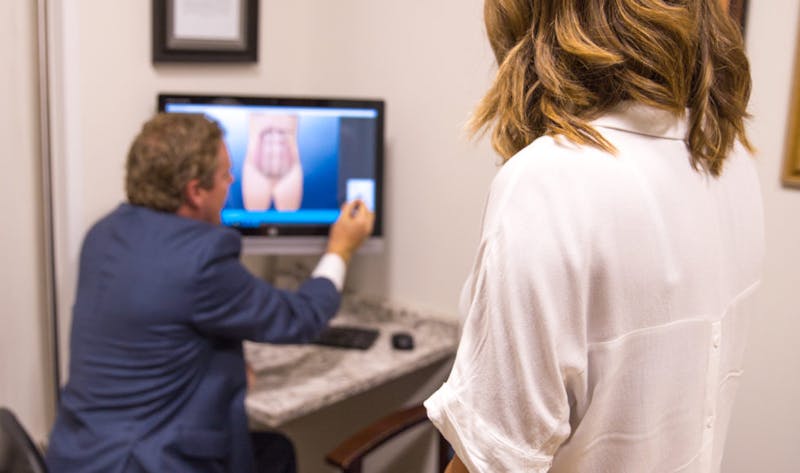 there is a man sitting at a desk with a computer and a monitor