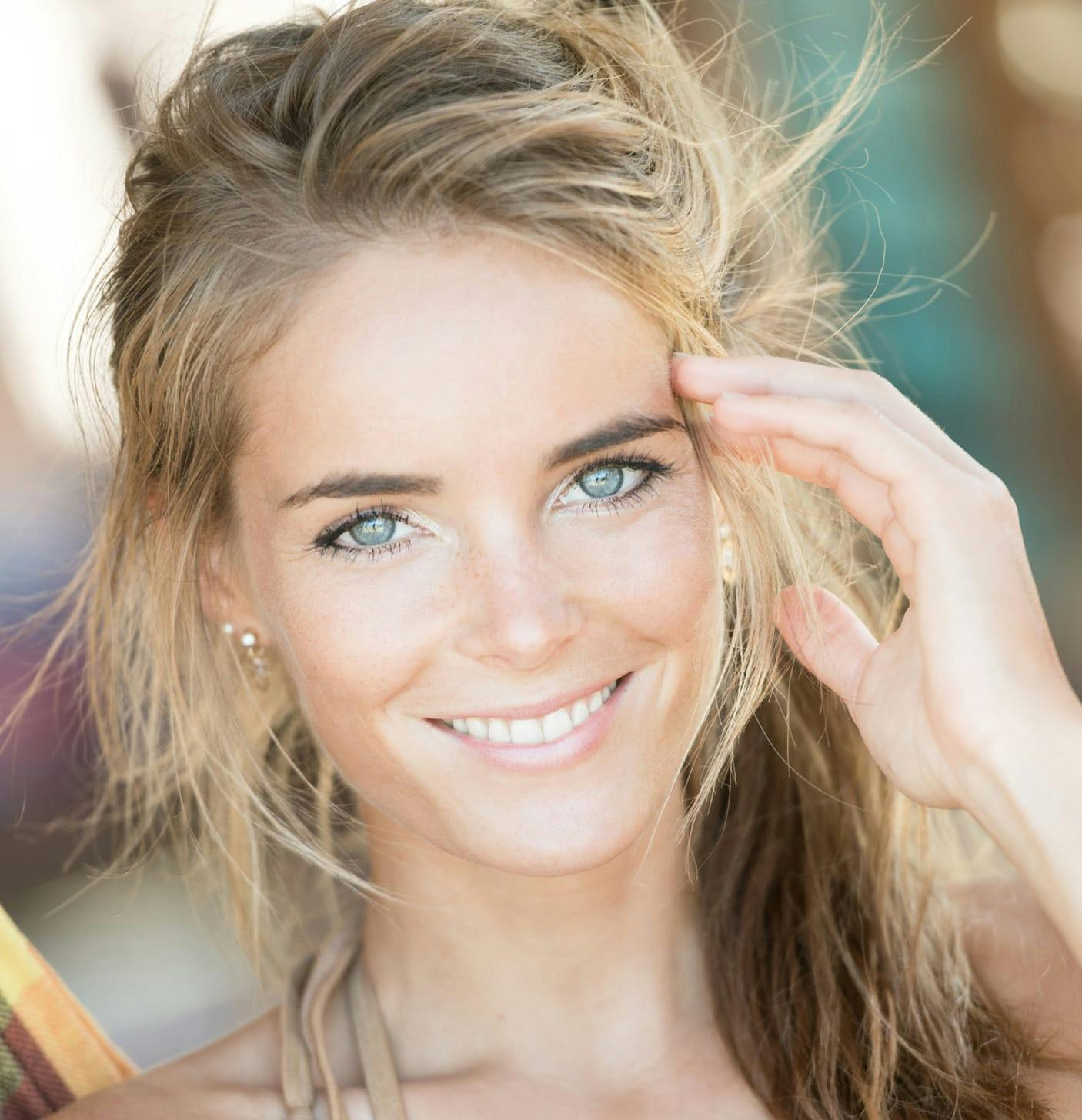 Woman smiling with a hand against her temple