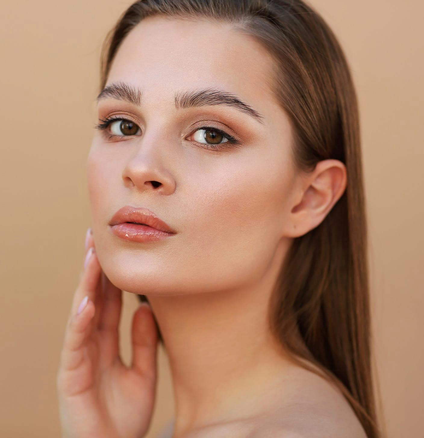 Woman with a hand to her face looking to the side