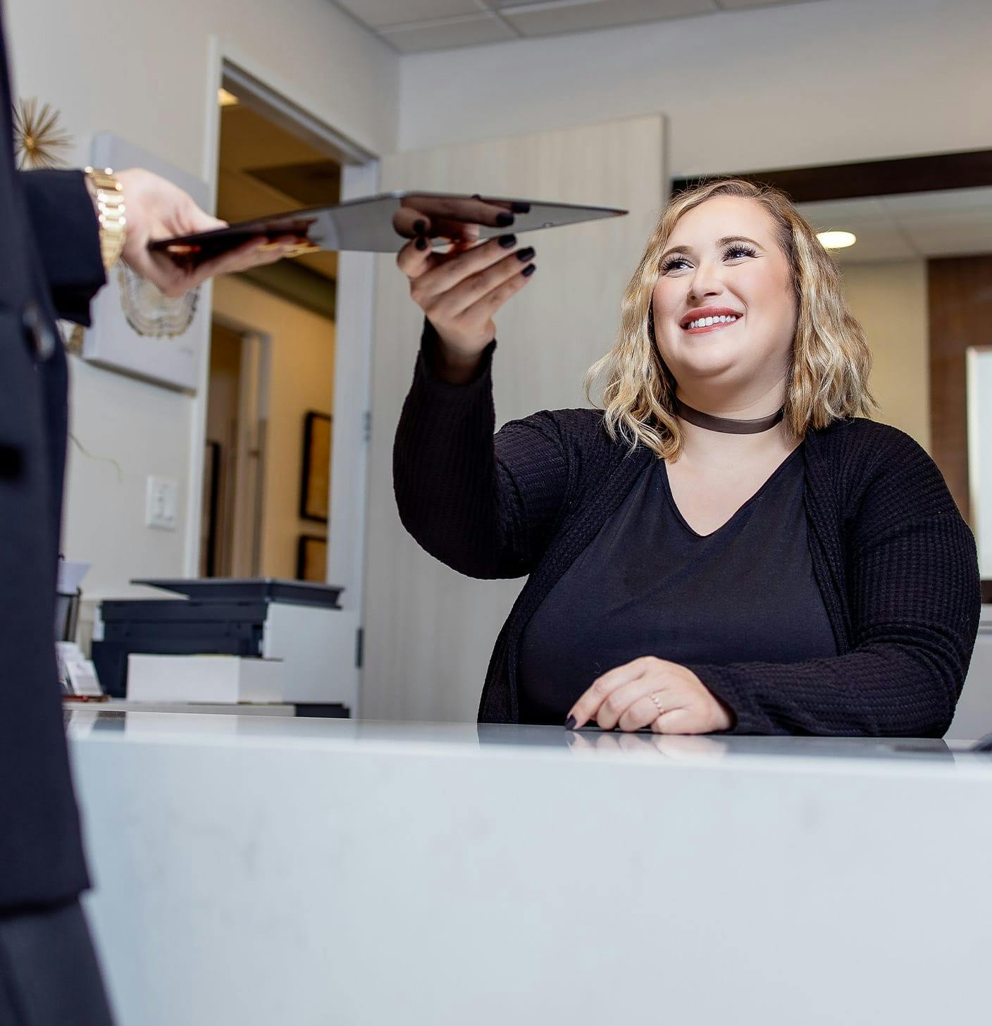 Front desk person receiving a tablet from a patient