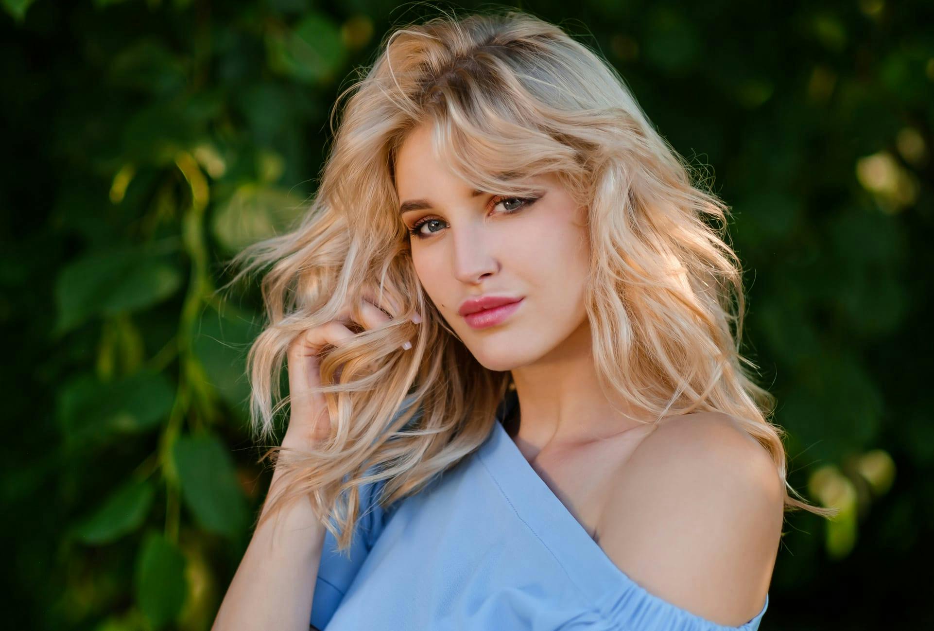 Woman with wavy hair in front of some plants