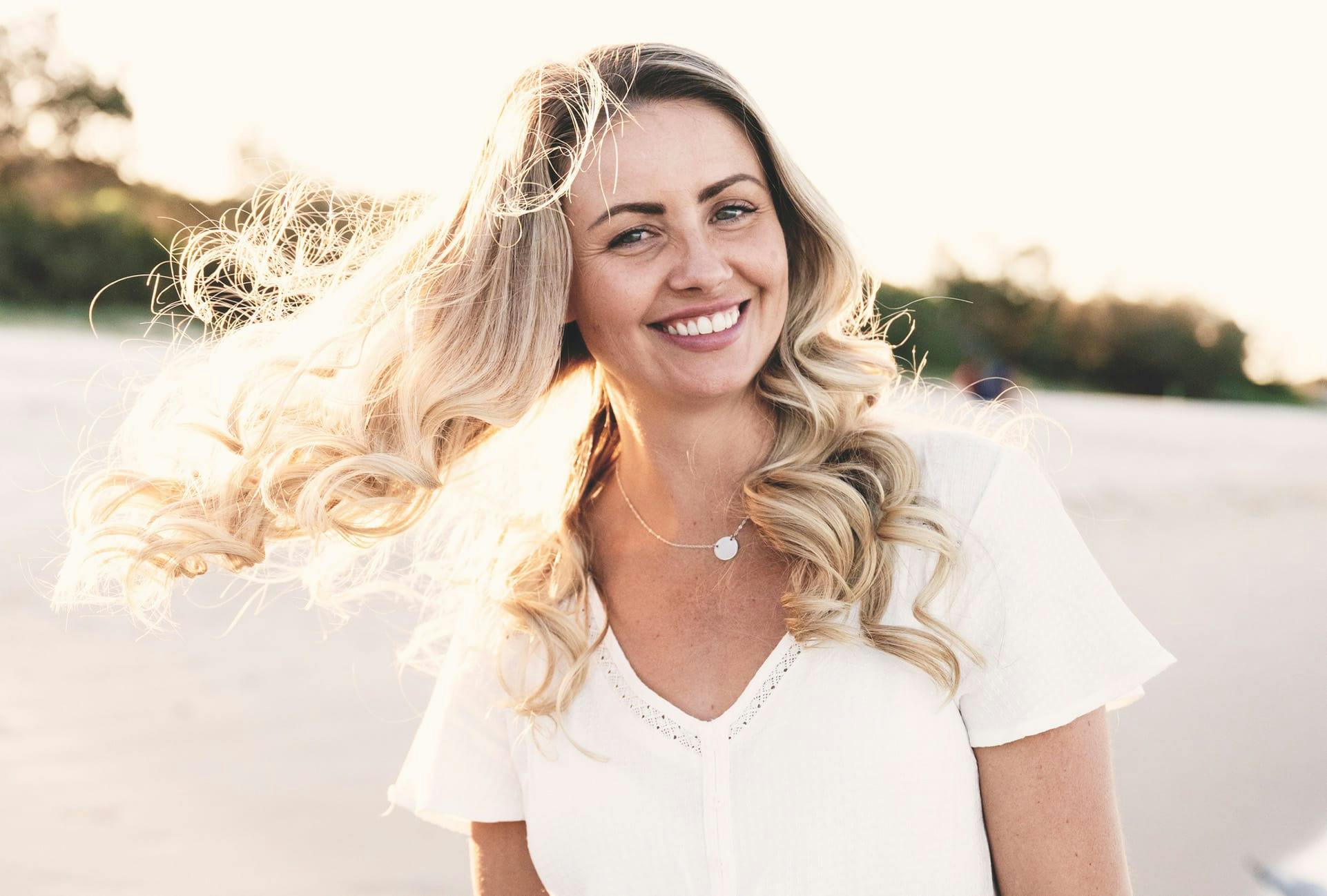 Woman in the sun on the beach, smiling