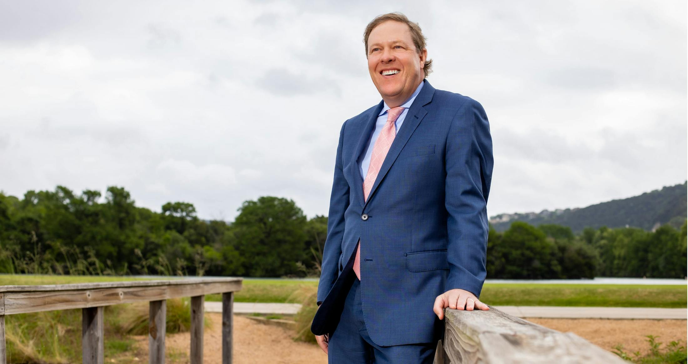 Dr. Haydon in a suit on a bridge, smiling