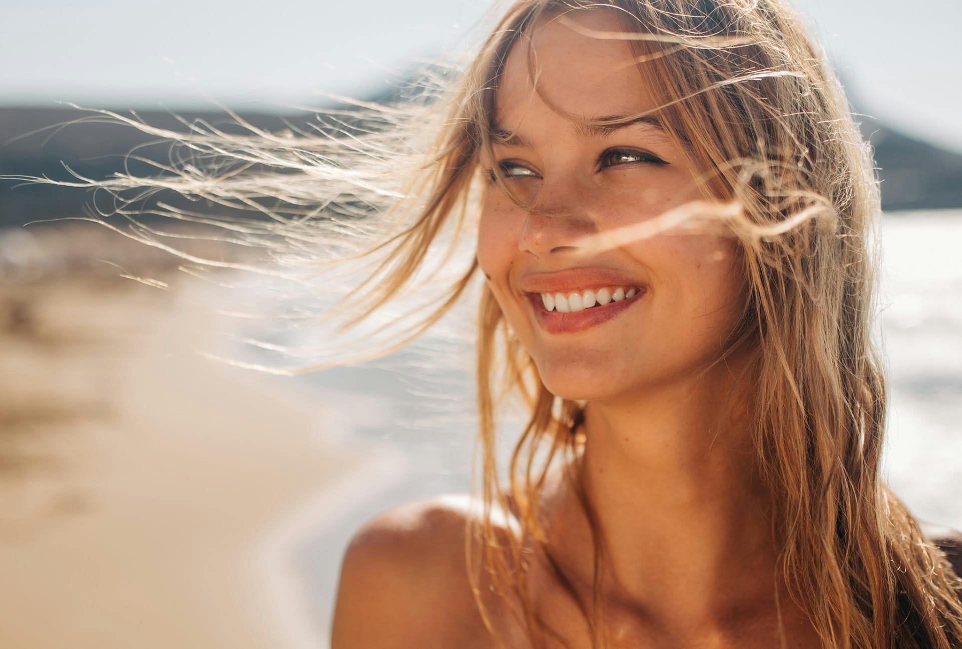 Close-up of a woman smiling on the beach