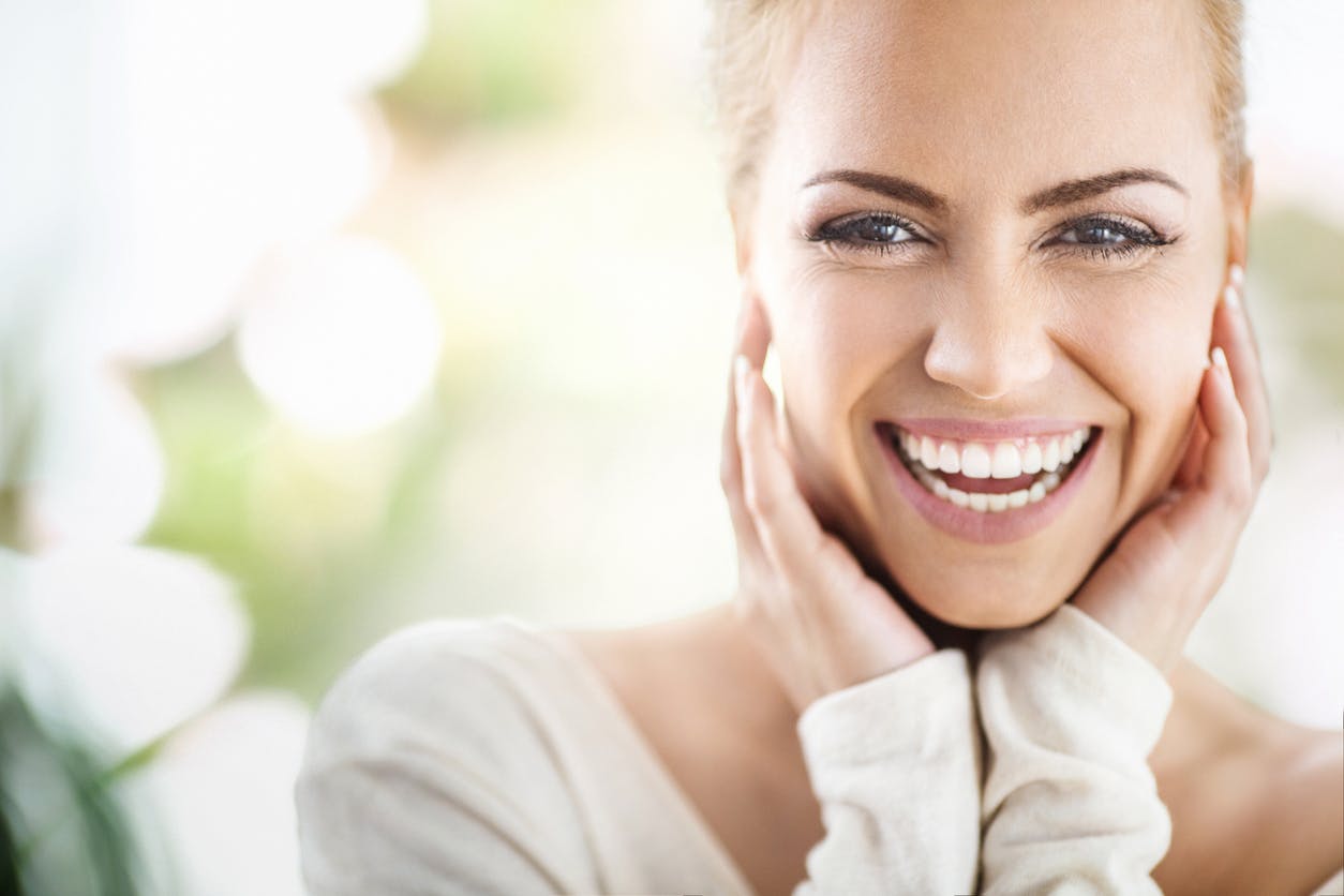 Woman smiling with hands under chin