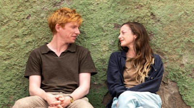 Domhnall Gleeson and Andrea Riseborough sit with their backs against the wall in Alice & Jack