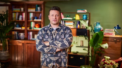 Jamie Oliver standing with arms crossed