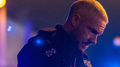 Martin Freeman, dressed in a police uniform, looks at the ground