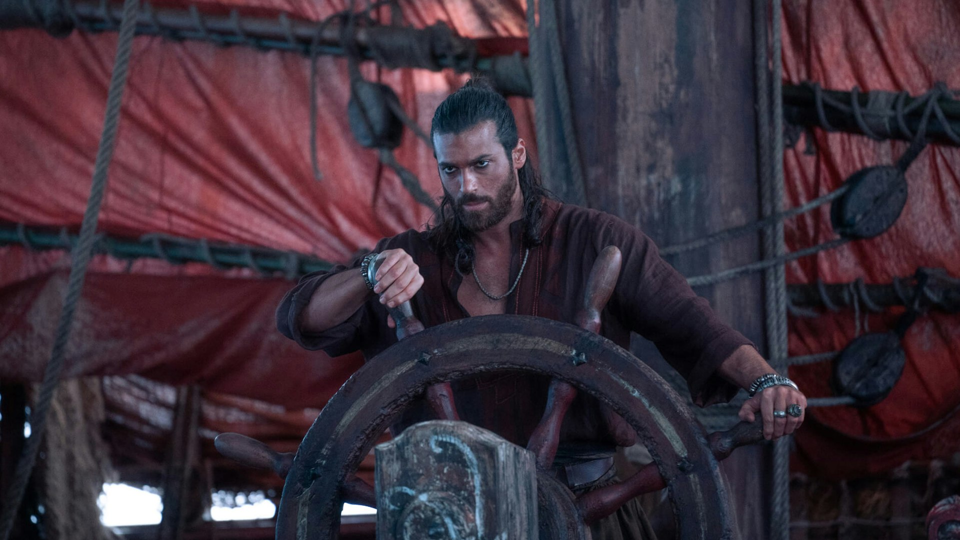 Can Yaman stars in the new Netflix series Sandokan A pirate-looking man stands behind the wheel of a ship looking focused