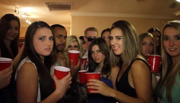 Image of a group of girls at a party staring at the camera with disgusted facial expressions