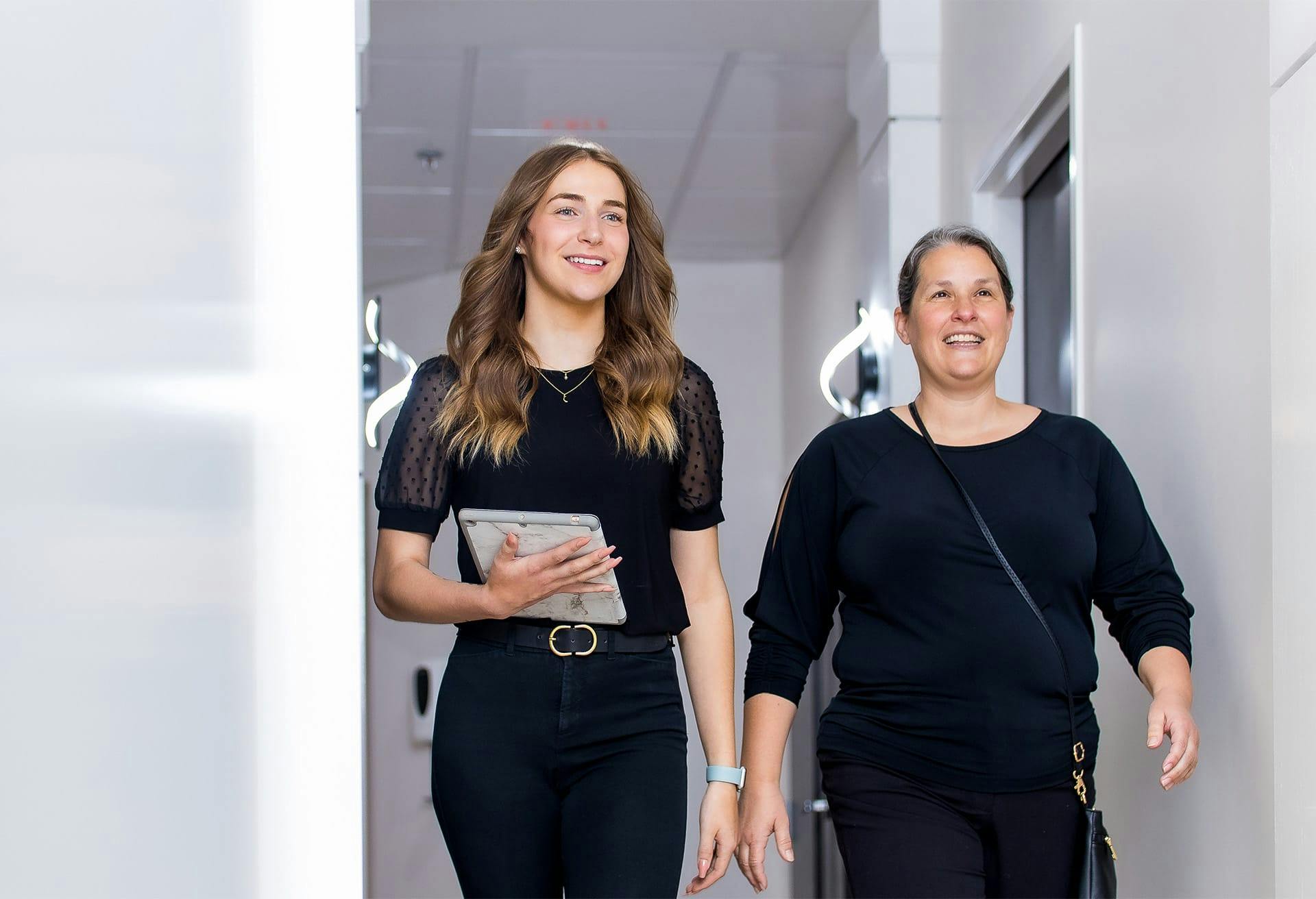 two women in a hallway smiling