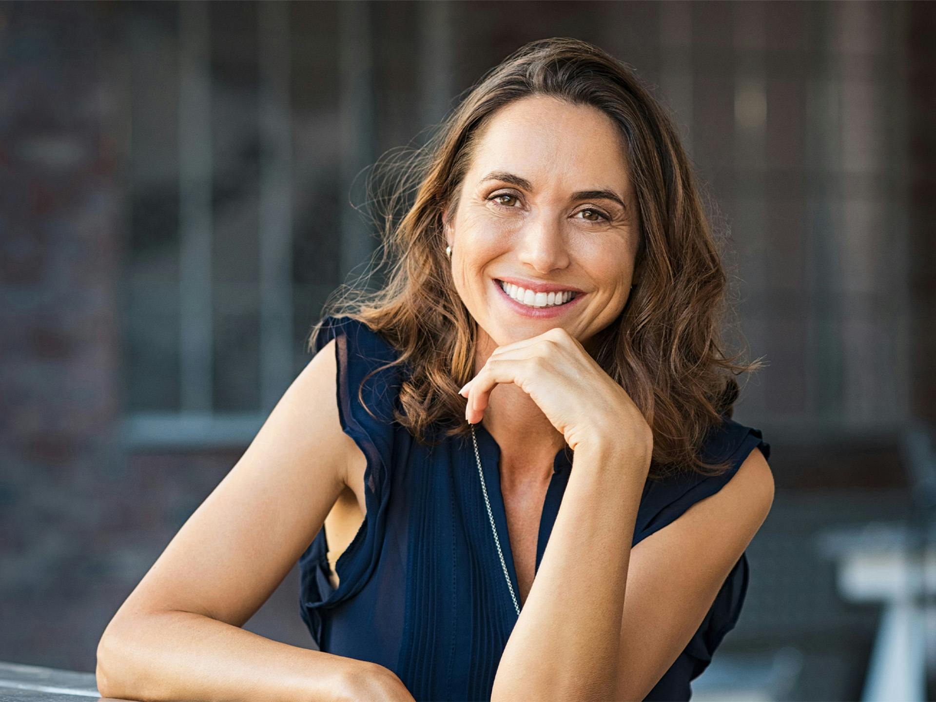 Woman smiling wearing a navy blouse