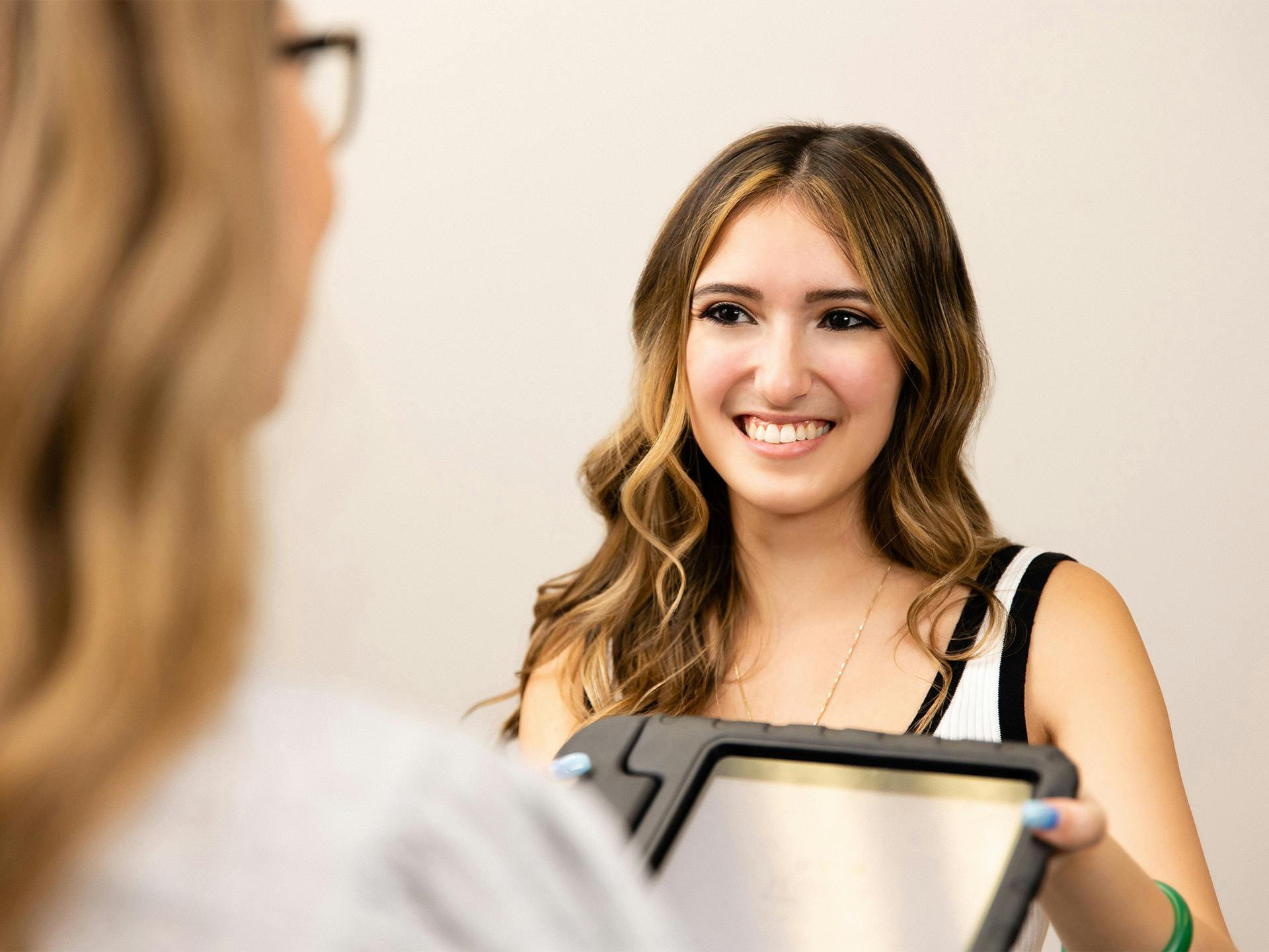 Woman handing over tablet