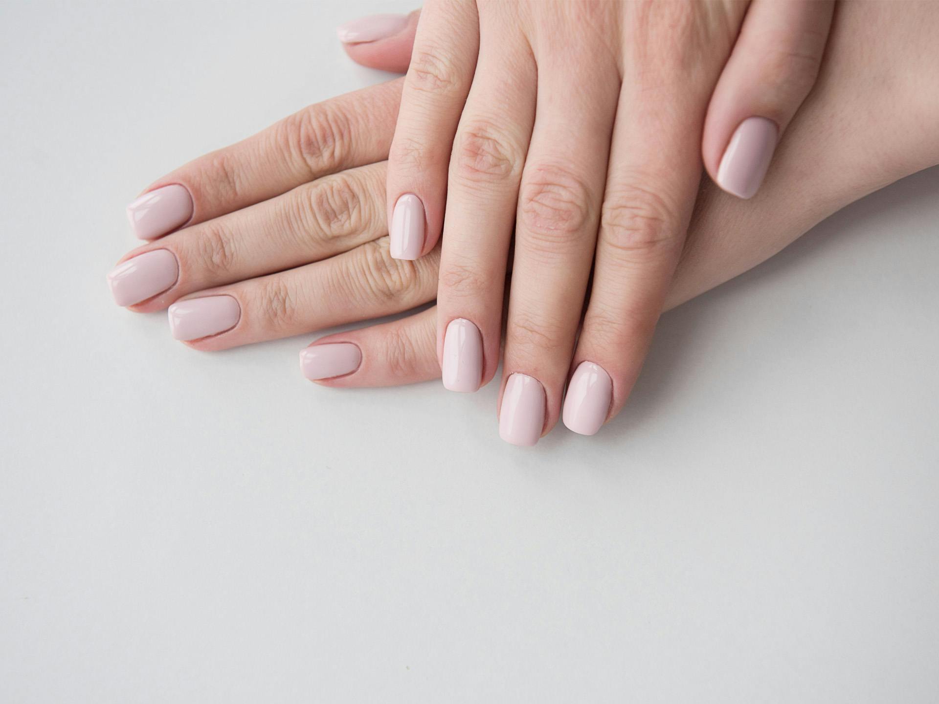Woman's hands with light pink nail polish