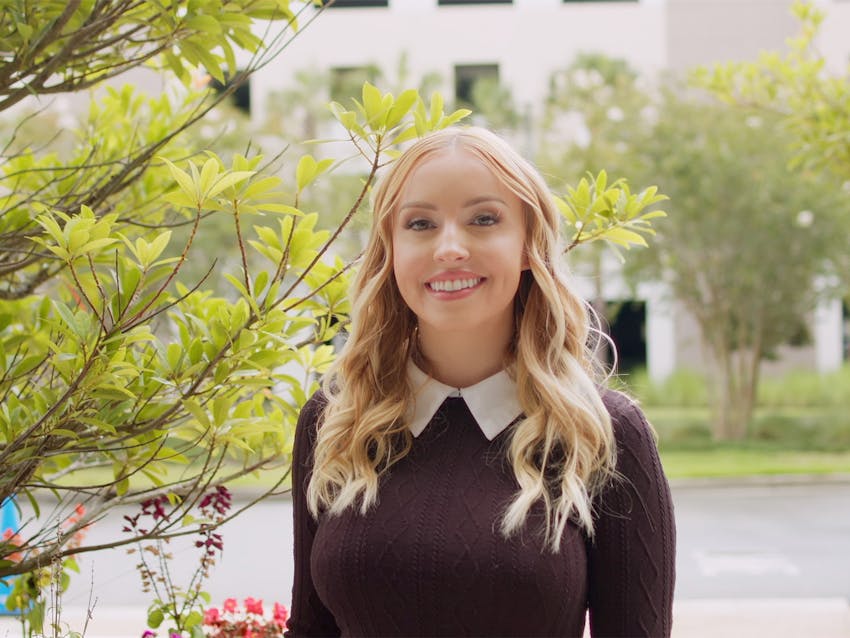 Blonde woman wearing a knitted sweater smiling