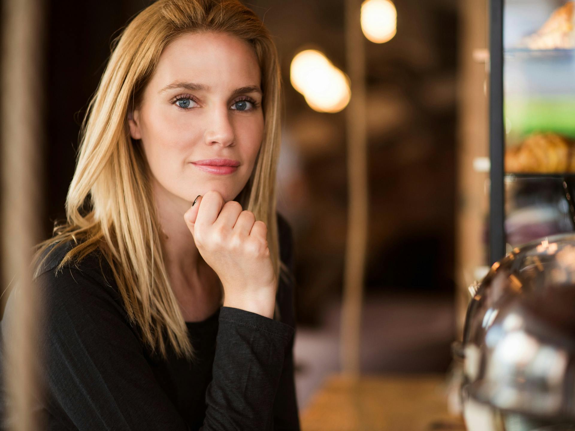 Blonde woman resting her face on her hand